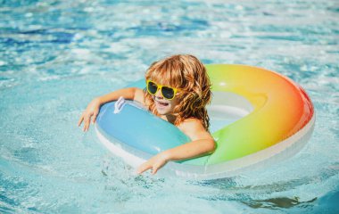 Yaz tatili. Yaz çocukları hafta sonu. Aquapark 'ta şişme lastik çemberde yüzen komik çocuk..