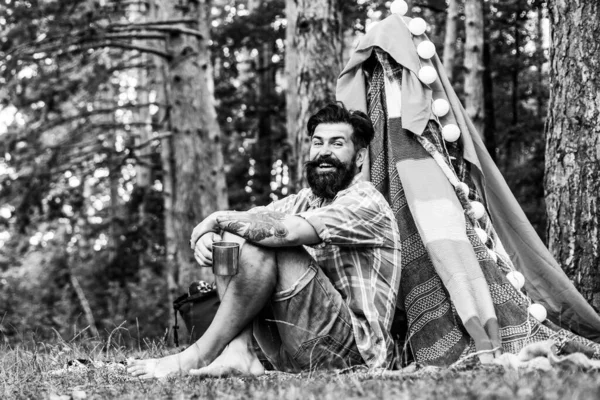 Tenda da campeggio nella giornata di sole. Uomo barbuto in tugurio. Il turismo si basa sulla natura. Campeggio estivo sulla natura. — Foto Stock