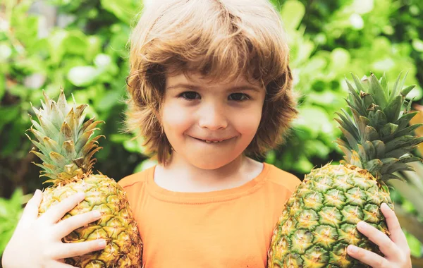 Jovem rapaz segurando abacaxi e sorrindo. Crianças com abacaxi . — Fotografia de Stock