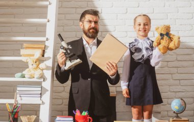 Öğretmen baba, yaratıcı kız çocuğuyla çalışıyor. Çocuk eğitimi, ilkokul ve öğrenme konsepti. Sınıftaki kız ve öğretmen..