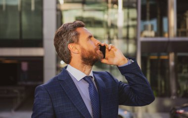 Akıllı telefon kullanan bir iş adamı. İş adamı telefonda konuşuyor..