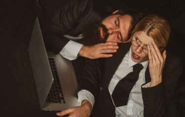 Karanlık ofiste uyuyan yorgun işadamı, ofiste çok çalışan genç bir iş kadını. Stresli genç iş kadınının iş yerindeki portresi. Ofis işi sonrası dizüstü bilgisayarda strese girdim. Son teslim tarihi.