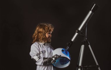 Kasklı küçük astronot portresi ve teleskoplu koruyucu uzay giysisi. Başarı, yaratıcılık ve başlangıç konsepti.