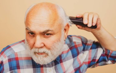 Saç makası olan adam. Yaşlı kel adam saç makası, olgun kellik ve saç dökülmesi konsepti..