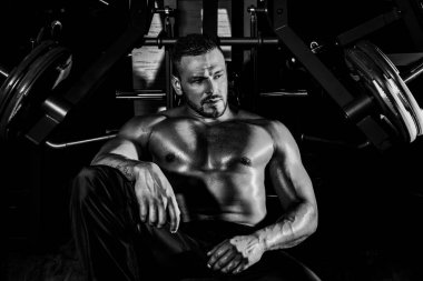 Eğitimden sonra yorgun sporcu dinleniyor. Bir şişe suyu ya da proteini olan bir adam. Spor salonundaki sporcu..