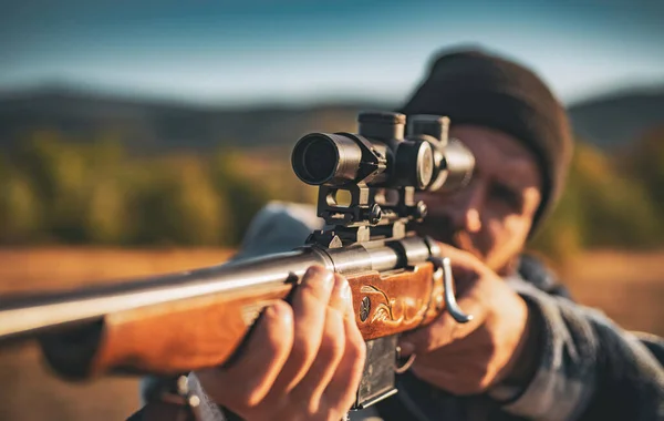 Hunter met krachtige geweer met bereik spotten van dieren. Hunter met jachtgeweer pistool op jacht. Hunter in de val jachtseizoen. — Stockfoto