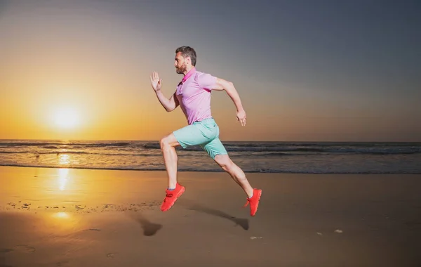 Junger athletischer und fitter amerikanischer Sportler beim Lauftraining bei Sonnenuntergang am Strand beim Joggen barfuß in gesundem Lebensstil-Konzept. — Stockfoto