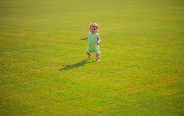 Healthy child. Baby boy toddler walking in a park on bright spring day. — Stock fotografie
