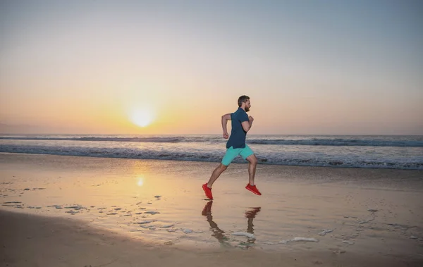 Mann läuft am tropischen Strand bei Sonnenuntergang. Gesunder Mann läuft und sprintet in voller Länge im Freien. Männlicher Läufer. Sport und gesunder Lebensstil. — Stockfoto