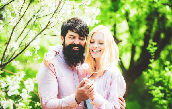 Några tillbringar tid i vårblommande trädträdgård. Grattis på påskdagen. Par skrattar och kramas. — Stockfoto