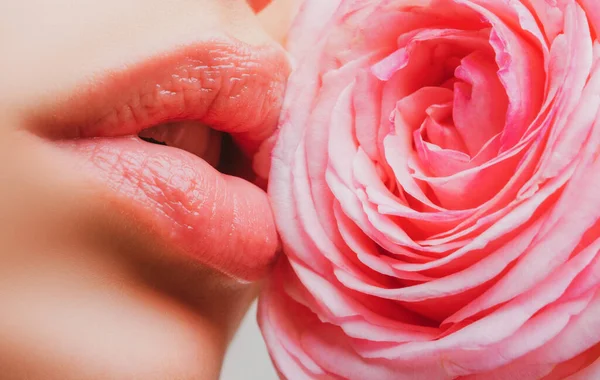 Junges Mädchen mit wunderschönem Nude-Make-up und prallen Lippen. Perfekte natürliche Lippen aus nächster Nähe. Schöne Frauenlippen mit Rose. — Stockfoto