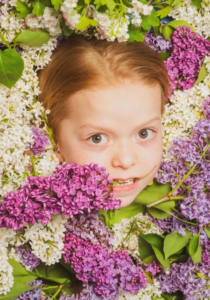 Funny little girl holding flowers in blooming summer garden. Teenager girl with bouquet of purple and white lilac. — Stock Photo, Image