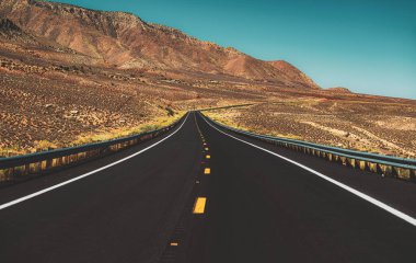 Asfalt desenli, arka planda. Kaliforniya 'nın Yucca Vadisi' ndeki Route 66 'da Mohave Çölü. Amerikan yol gezisi.