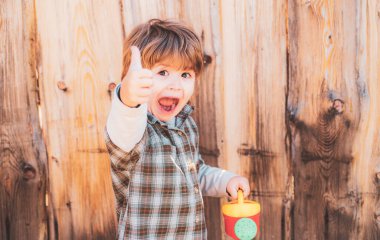 Kürek ve sulama kutusuyla mutlu bir çocuk. Bahar bahçesinde çiçekleri sulayan sevimli küçük çocuk. Bahçe araçları.