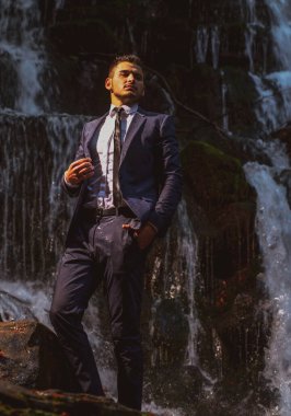 Başarılı modern iş adamı. Kariyer üstü. Şelale arka planında takım elbiseli yakışıklı bir iş adamı..