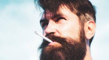 Sigara içen bir delikanlıyı yakından çek. Adam sigara içiyor..