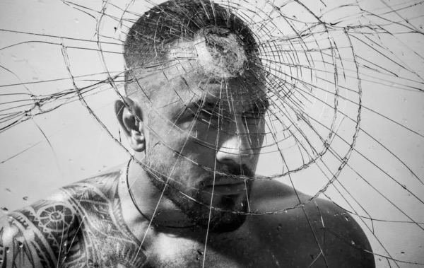 Overcoming the obstacle. Determined man knocking down a glass wall with a head, obstacle concept. Strong latino man removing obstacle on his way. Facing obstacle to goal achievement — ストック写真