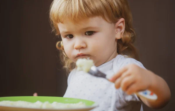 Bebé bonito está sendo alimentado usando colher. — Fotografia de Stock
