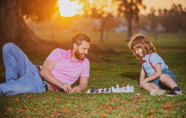 Mio padre gioca a scacchi con mio figlio. Famiglia fuori gioco. Giovane ragazzo picchiare un uomo a scacchi. — Foto Stock