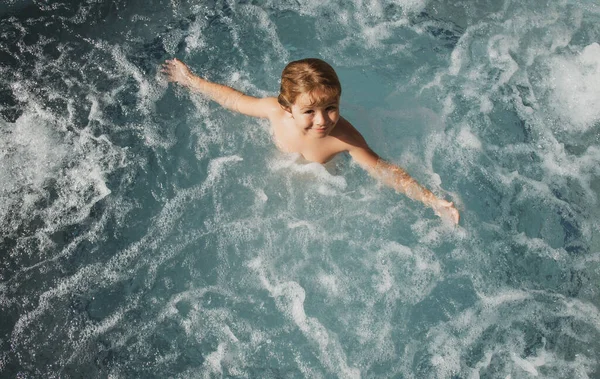 Criança engraçada curtindo o verão na piscina. Spa de banheira quente. — Fotografia de Stock