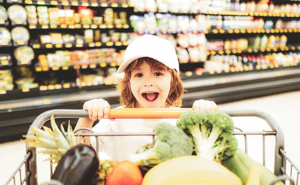 Concetto di vendita, consumismo e persone: bambini entusiasti con cibo nel carrello della spesa al supermercato . — Foto Stock