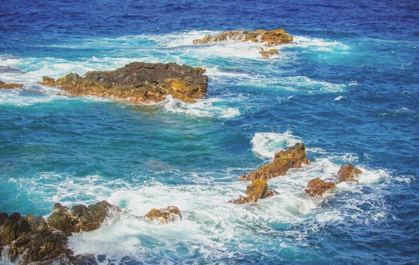 Espalhando ondas na rocha no mar. Onda atingiu a pedra no oceano com um fundo de água. — Fotografia de Stock