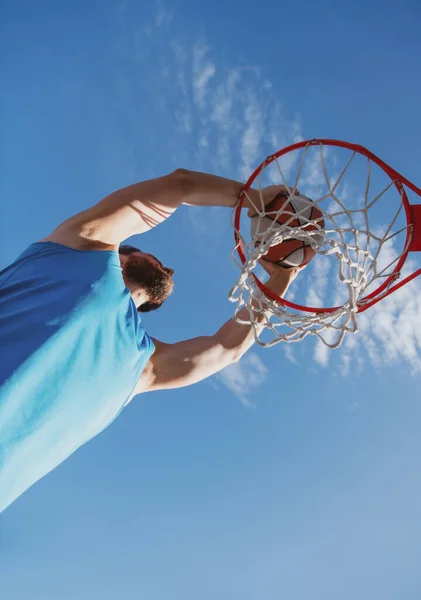 Giocatore di basket che spara palla in cerchio campo esterno. Gioco giovanile urbano. Concetto di successo sportivo, punti e vittorie. — Foto Stock