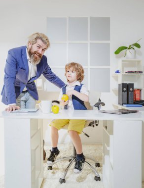 İş adamı olmanın hayalini kuran küçük çocuk. Çocukluk ve rüya kavramı. Takım elbiseli dört iş arkadaşı proje üzerinde çalışıyor. Takım çalışması ve iş dünyası aile takımı.