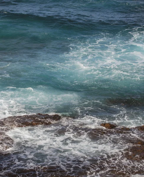 海的背景风暴来临前，海浪以浪花和泡沫冲刷岩石海岸. — 图库照片