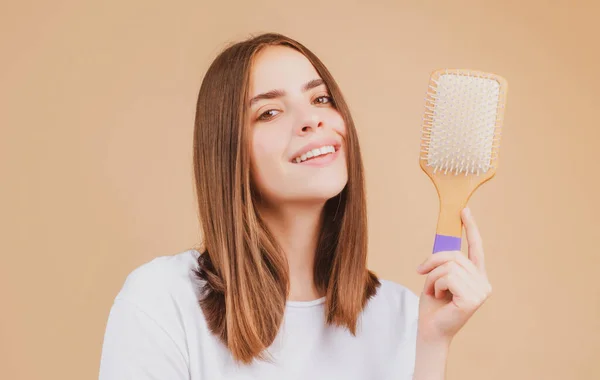 Saç fırçalamak. Genç bir kadının portresi, düz saçlarını tarak ile tarıyor. Saç fırçasıyla sağlıklı saçlarını tarayan bir kız. Saç bakımı güzellik konsepti. — Stok fotoğraf