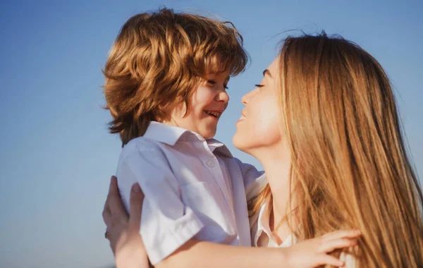Concepto del día de las madres. Hijo hijo abrazo mamá. Madre e hijo sonriendo y abrazándose. Vacaciones familiares y unión. —  Fotos de Stock