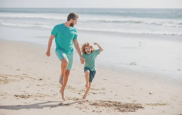 Pai e filho a correr no mar. Conceito de família feliz. — Fotografia de Stock