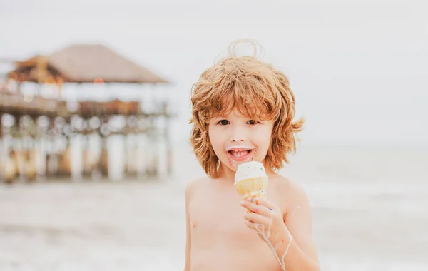 Odkryty z bliska portret słodkie dziecko jedzące lody w lecie gorącej pogody. Mały i ładny chłopiec jedzący lody na plaży na wakacjach. — Zdjęcie stockowe