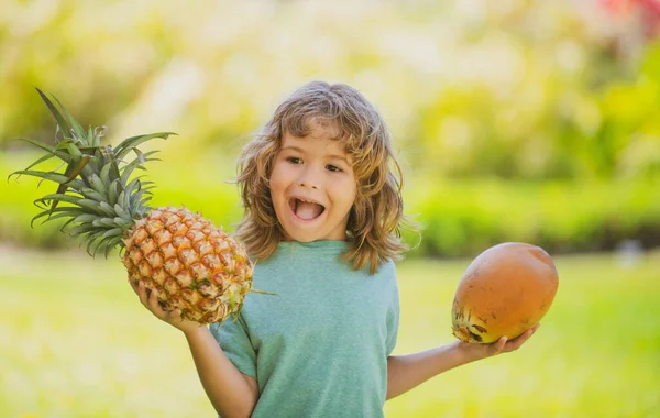 Menino com abacaxi e coco. Criança com fruta de verão. — Fotografia de Stock