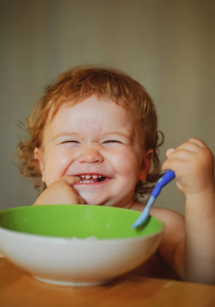 Bebê sorrindo comendo comida. Lançamento criança com colher. — Fotografia de Stock