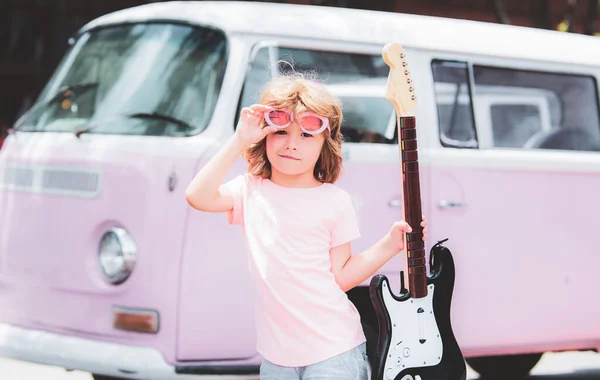 エレキギターを演奏ピンクのサングラスで男の子の肖像画。未来のロックスター. — ストック写真