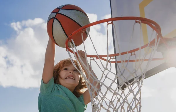 Barn som spelar basket. Barnsport aktivitet. Friska barn livsstil. Närbild ansikte unge basketspelare att göra slam dunk. — Stockfoto