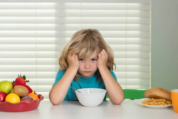 Portret van een kind zonder eetlust. Begrip verlies van eetlust. Gezonde voeding voor kinderen. Leuke jongen geniet van het ontbijt met eetlust. Hongerig kind eet smakelijk fruit en groenten — Stockfoto