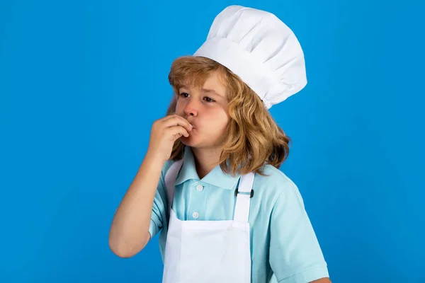 Şef şapkalı ve önlüklü çocuk yemek hazırlıyor. Mutfakta sebzeli küçük bir aşçı. Doğal çocuk yemekleri.. — Stok fotoğraf