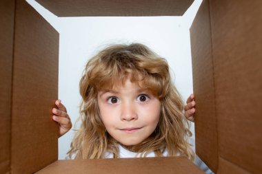 Karton kutulu mutlu çocuk, internet mağazasından paketleri açıyor. Çocuk müşteriler hızlı teslimat hizmetinden memnun. Paketler ve teslimat.