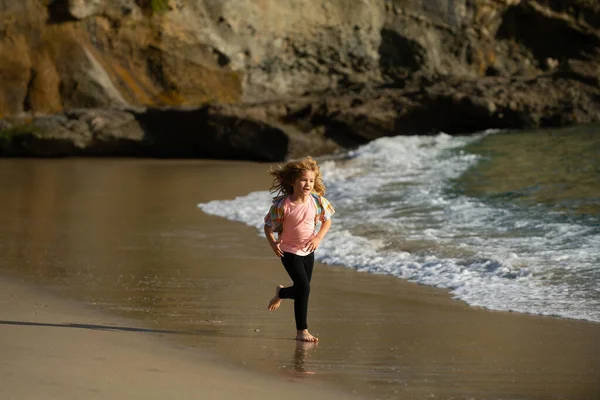 Enfant traversant l'eau près du rivage le long de la plage de la mer. Un garçon court le long de la côte. Reste des enfants en vacances d'été. Course et sport sain pour les enfants. — Photo