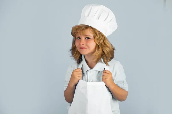 Aşçı çocuk sağlıklı yemek için taze sebze yapıyor. Gri arka planda izole edilmiş küçük çocuk portresi. Aşçı çocuk. Yemek pişirme süreci. — Stok fotoğraf
