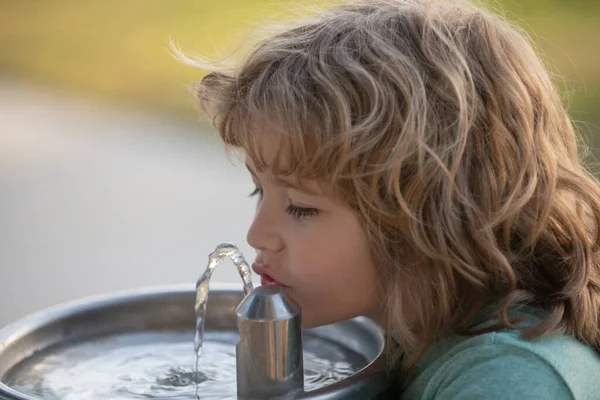 옥외 샘에서 물을 마시는 어린이의 모습을 가까이 서 본 모습. — 스톡 사진