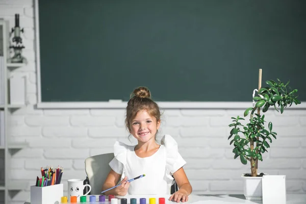 Słodki mały przedszkolak dziewczynka rysunek w szkole. Malowanie dziewczynki w podstawówce. Koncepcja kreatywnej edukacji dzieci — Zdjęcie stockowe
