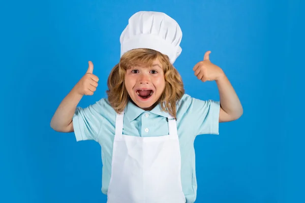 Excited funny chef cook. Child chef dressed cook baker apron and chef hat with thumbs up isolated on studio background.