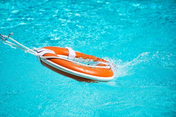 Lifebuoy pool ring float on blue water.