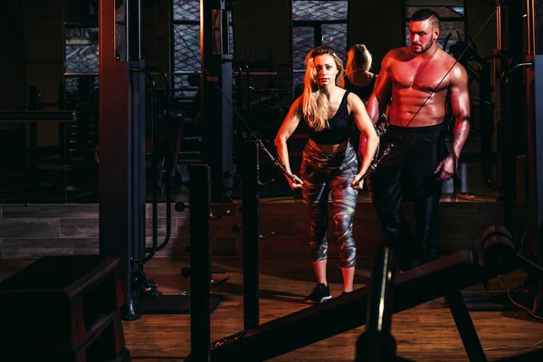 Allenamento sportivo di coppia in palestra. Allenatore muscolare uomo formazione donna. Personal trainer istruttore di fitness. — Foto Stock