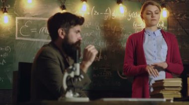 Öğretmen ve üniversite öğrencisi sınıfta. Üniversitede ödev yapmayı düşünen bir kız öğrenci. Profesör öğretmenlik konsepti. Üniversitedeki kadın ve erkek tahtada