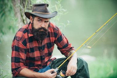 Man with fishing rod, fisherman men in river water outdoor. Summer fishing hobby