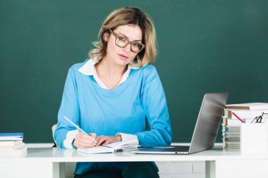 Sınıfta karatahta kitapları olan genç bir bayan öğretmen. Öğrenci kız üniversitede ders öğreniyor. eğitim, lise ve halk konsepti